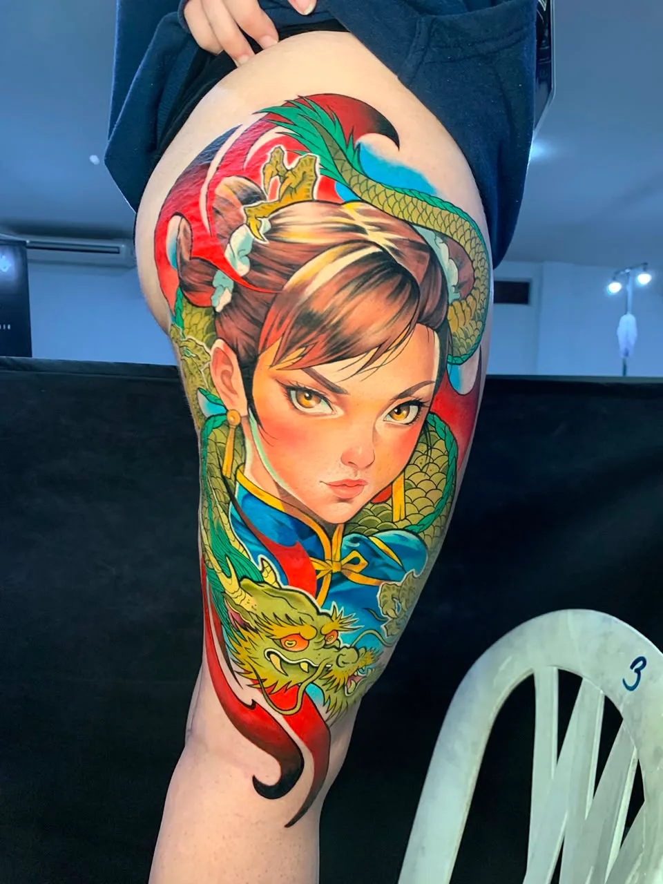 Tatuagem colorida de personagem com dragão verde
