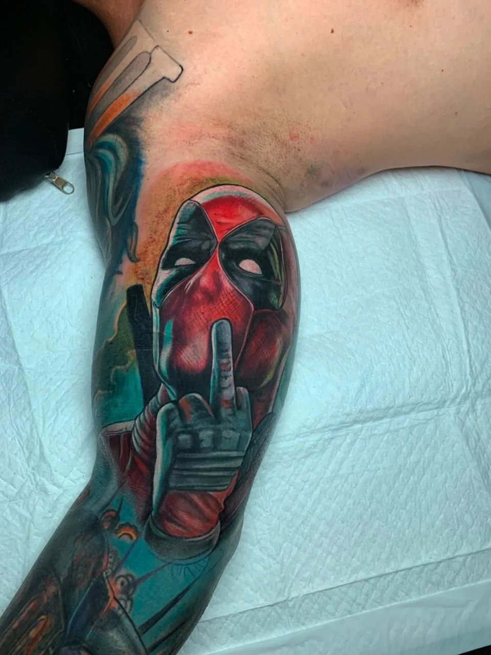 Tatuagem colorida do Deadpool no braço