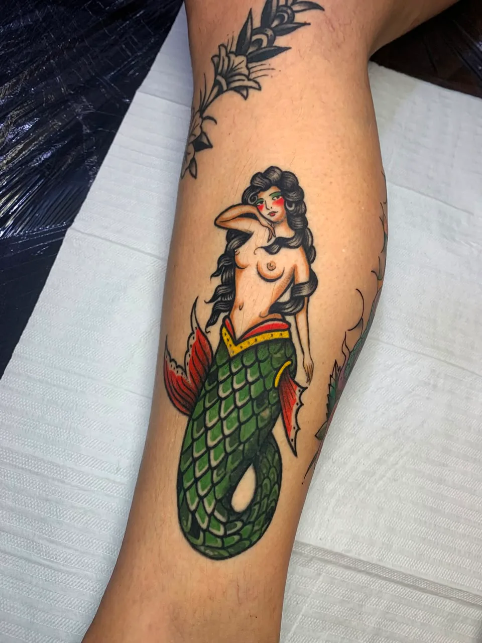 Tatuagem colorida de sereia na perna
