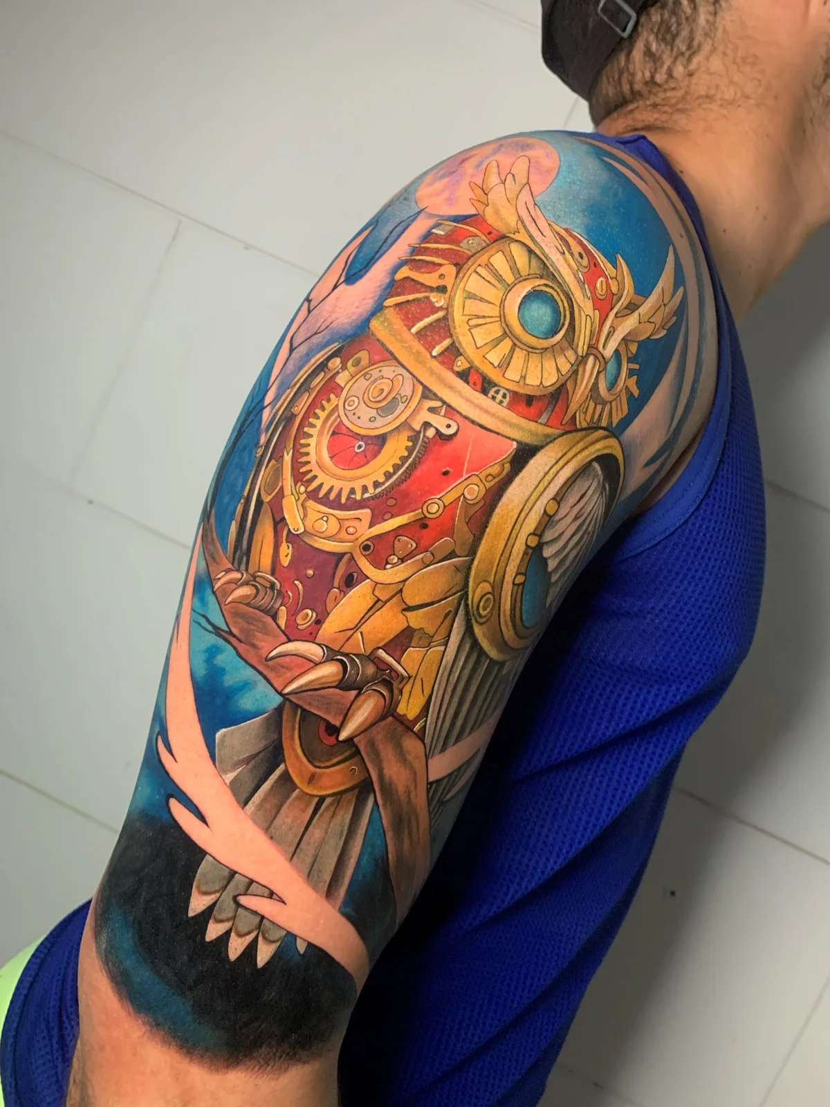 Colorful ornamental tattoo with gears on the shoulder